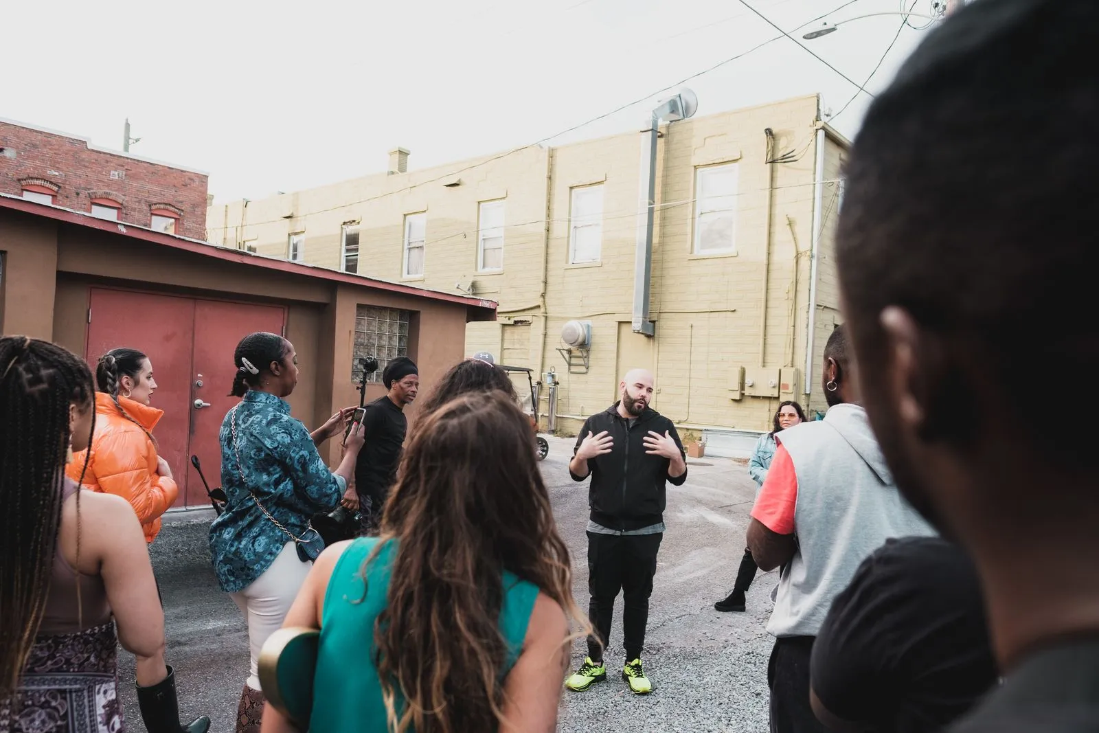 A diverse group of adults engaging in a community meeting on an urban Sanford street.